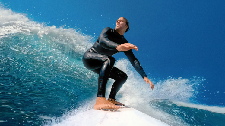 surfer riding a wave using the insta360 floating surfboard mount to film himself